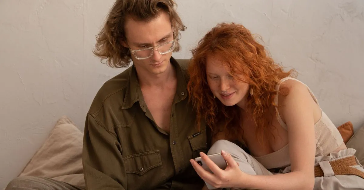 Two people reading a chat on a phone together